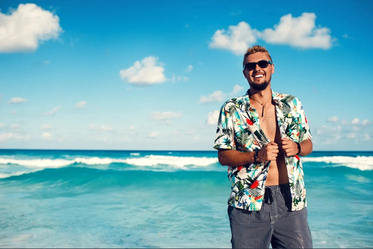 A man posing while wearing men's Hawaiian shirts