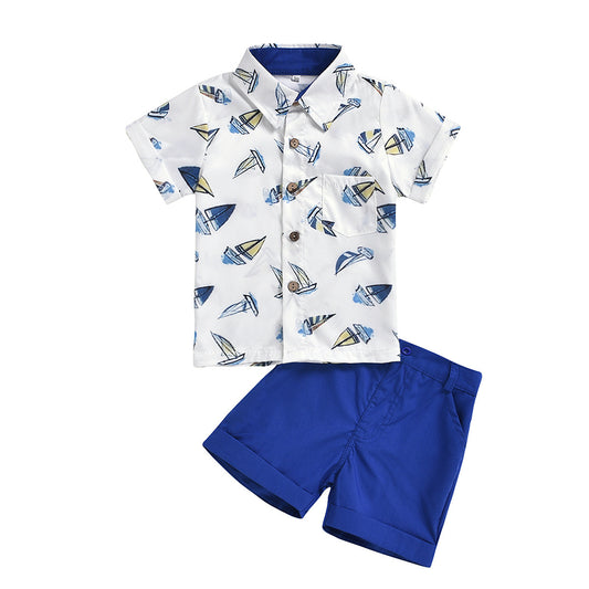 Young child in a summer outfit featuring a sailing print shirt and matching shorts.