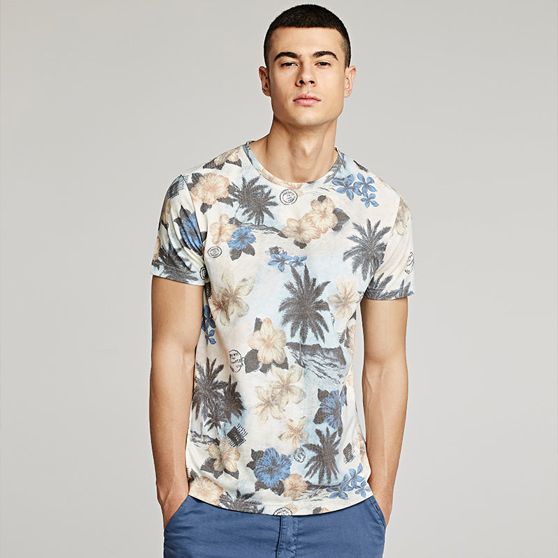 A young man from America is wearing a Men's Floral Print Short Sleeve Beach T-Shirt