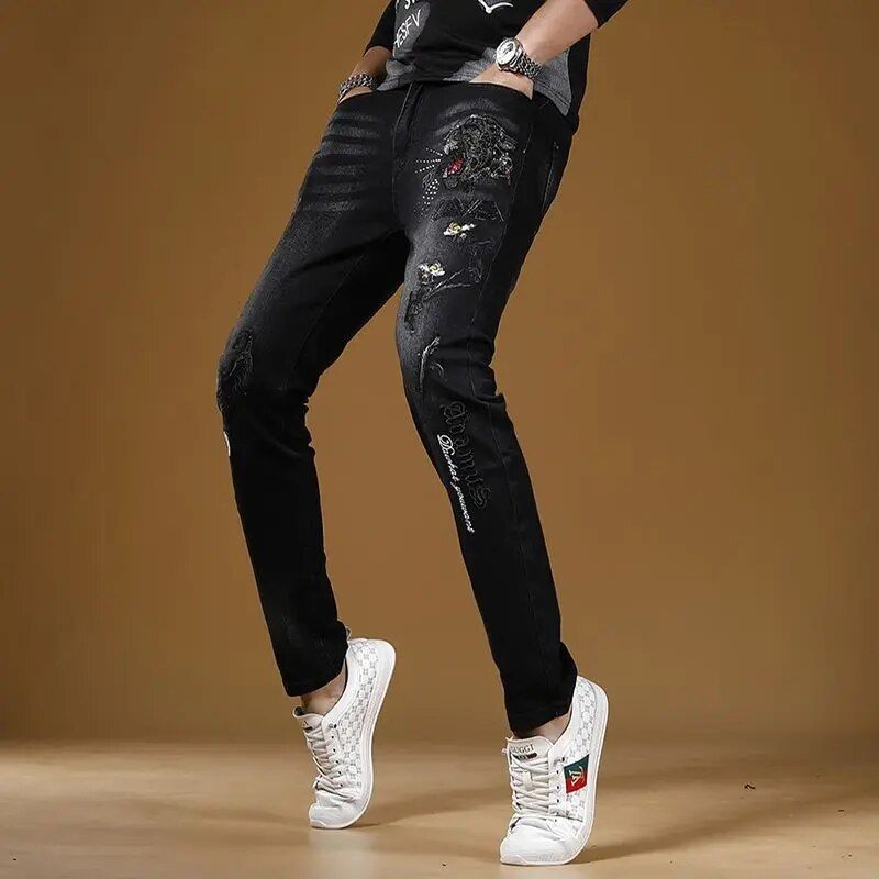 Men's slim fit black denim jeans on brown background